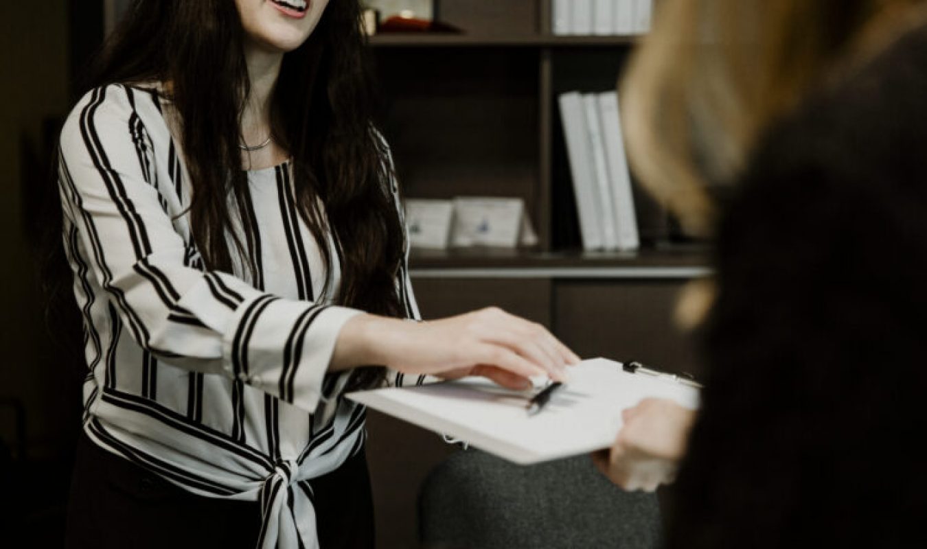 Duas mulheres assinando um contrato empresarial felizes